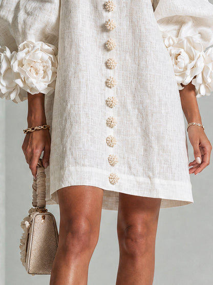 Mini-robe blanche à boutons, motif floral, avec des poignets à motif floral saisissants